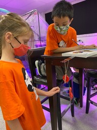 Two grade four students learning how a fixed pulley works